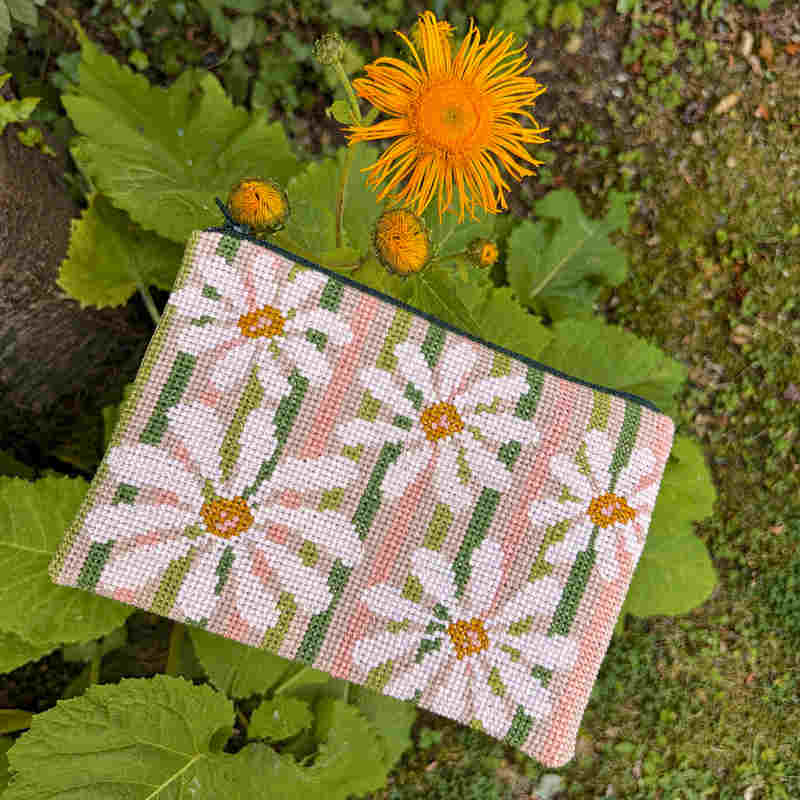Pomp Stitch clutch med margueritter på stribe