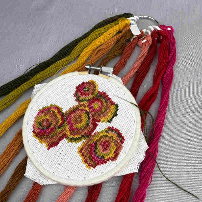 broderigarn i organiser - røde og gyldne farver fra tekstilmagi